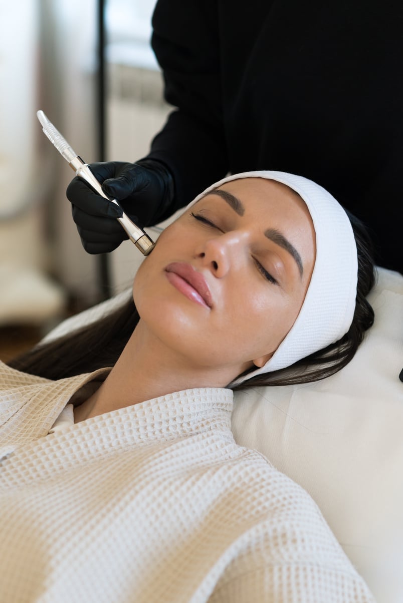 Professional female cosmetologist doing Hydrafacial procedure in Cosmetology clinic. Stock photo